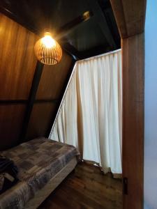 une chambre avec un lit et un lustre dans l'établissement ESB Chalés, à Poços de Caldas
