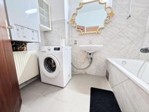 Lovely Rooms in Märzstraße Area MZ49 في فيينا: حمام مع غسالة ومغسلة