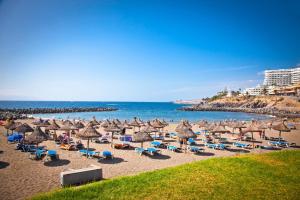 a beach with umbrellas and chairs and the ocean at Sea views Estudio Ponderosa near the beach in Costa de Adeje +2 photos
