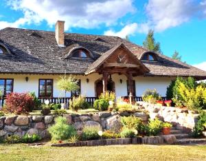 a house with a stone retaining wall at Dworek Mieldziczowka in Supraśl