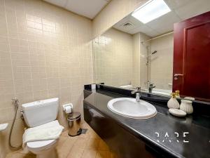 a bathroom with a sink and a toilet and a mirror at Rare Holiday Homes - Mediterranean Cluster - Near Ibn Battuta Mall - Discovery Garden - Building# Med 49 - R514 in Dubai