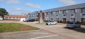 un parcheggio con auto parcheggiate davanti a un edificio di Red Roof Inn & Suites Euless - DFW Airport Southwest a Euless
