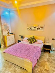 1 dormitorio con 1 cama con edredón morado en Teranga SN, en Dakar