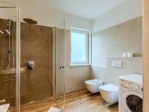 uma casa de banho com um WC e uma máquina de lavar roupa. em Apartment Nespolo by Interhome em Dro