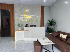 a woman standing at a desk in a key night hotel at Sky Night Hotel 2 in Việt Yên