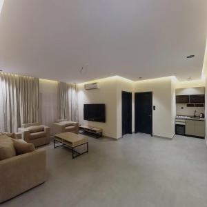 a large living room with a couch and a tv at منتجع هدب للشقق المخدومة in Taif