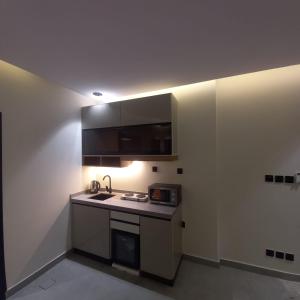 a small kitchen with a sink and a microwave at منتجع هدب للشقق المخدومة in Taif +13 photos