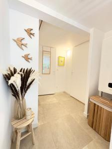 Appartement Cozy T2 proche de la mer في سانت أي جولف: ممر به إناء من الزهور على الحائط +10 صور