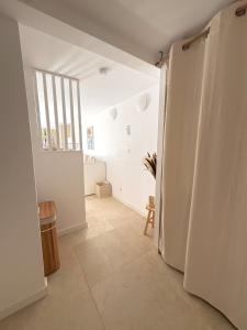 Appartement Cozy T2 proche de la mer في سانت أي جولف: ممر به باب مفتوح على غرفة ذات جدران بيضاء