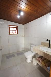 a bathroom with a toilet and a sink at Mirantes Paraibuna - Casa Rosada in Paraibuna +20 photos