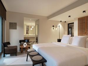 a bedroom with a large white bed and a chair at The Chedi El Gouna in Hurghada