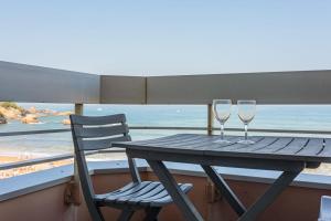 einen Tisch mit zwei Weingläsern und einem Stuhl auf dem Balkon in der Unterkunft Studio Helder vue mer - Welkeys in Biarritz