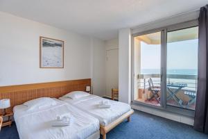 ein Schlafzimmer mit zwei Betten und einem großen Fenster in der Unterkunft Studio Helder vue mer - Welkeys in Biarritz