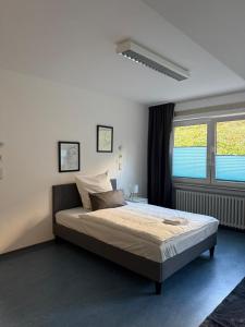 Un dormitorio con una cama y dos ventanas. en Möblierte Monteurzimmer in zentraler Lage in Büren, en Büren