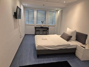 Un dormitorio pequeño con una cama y un escritorio. en Möblierte Monteurzimmer in zentraler Lage in Büren, en Büren