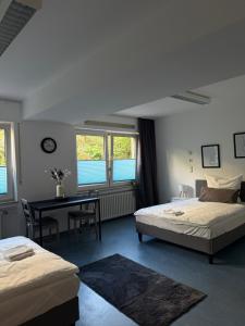 Un dormitorio con dos camas y una mesa y un escritorio. en Möblierte Monteurzimmer in zentraler Lage in Büren, en Büren