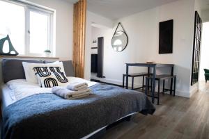 a bedroom with a bed with a table and a mirror at Dorset Stylish Apartment in Poole