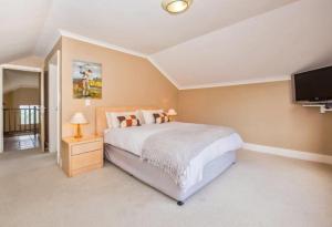 克尼斯纳Pezula Golf Villa的一间配有大床和平板电视的卧室