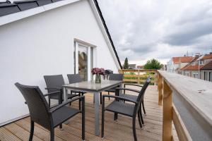 ノイシュタット・イン・ホルシュタインにあるLuxus Fairschlafen am Hafen mit Sauna und BBQのバルコニーにテーブルと椅子が置かれたパティオ