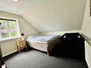 a small bedroom with a bed and a window at Vejle Apartment Skovhøjen in Vejle