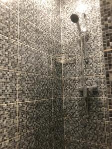a bathroom with a shower with black and gray tiles at Seatime Studio in primul rând la mare in Mamaia Sat/Năvodari +25 photos