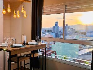 a dining room with a table and a large window at Studio 11 Refugio Relaxante Mogi in Mogi das Cruzes