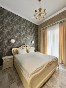 a bedroom with a large bed and a chandelier at Siena Hotel in Odesa