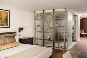 a bedroom with a bed and a glass wall at 1926 Les Bains Private Spa Suites in Sliema