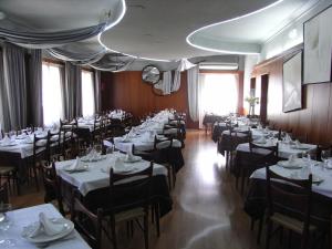 a dining room with tables and chairs with white tablecloths at Hotel El Mesón in Javier