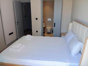 a white bed with two towels on top of it at Exclusive Residence Famagusta in Famagusta