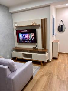 a living room with a flat screen tv on a wall at Studio 11 Refugio Relaxante Mogi in Mogi das Cruzes
