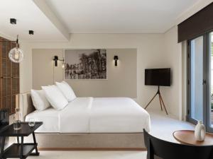a white bedroom with a large bed and a table at The Chedi El Gouna in Hurghada