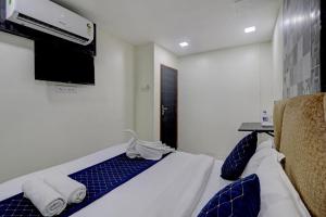 ein Hotelzimmer mit einem Bett und einem Flachbildfernseher in der Unterkunft Parle Inn Hotel in Mumbai