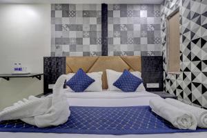 ein Schlafzimmer mit einem großen Bett mit Handtüchern darauf in der Unterkunft Parle Inn Hotel in Mumbai