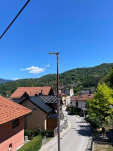 a street in a small town with a mountain at Apartman David in Jajce