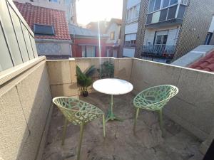 a patio with a table and two chairs on a balcony at La Casita de Vane - Casa en el centro con parking privado a unos 250 metros in Cangas de Morrazo