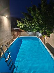 a large blue swimming pool at night at Niki's House in Gournes