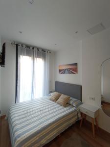 a bedroom with a bed and a window at La Casita de Vane - Casa en el centro con parking privado a unos 250 metros in Cangas de Morrazo