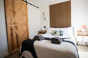a bedroom with a bed with towels on it at Dorset Stylish Apartment in Poole