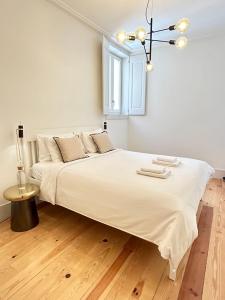 Una cama blanca grande en una habitación con ventana. en Santa Justa Cozy Room, en Lisboa
