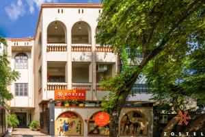 a large white building with a tree in front of it at Zostel Agra in Agra