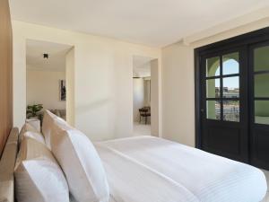 a bedroom with a white bed with white pillows at The Chedi El Gouna in Hurghada
