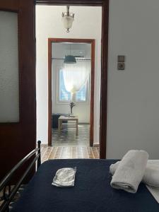 a bedroom with a bed and a hallway with a window at Elaia House-Eλαία in Spetses