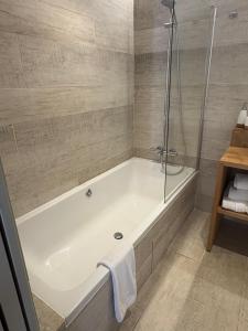 a bathroom with a bath tub and a shower at La Maison de la Tour in La Tour