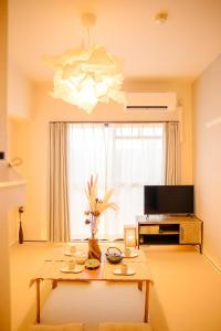 a living room with a table and a large window at 和605 名駅徒歩圏 地下鉄徒歩3分 最大4名 洗面台 浴室 トイレ別 長期滞在可乾燥機付き in Nagoya