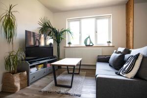 a living room with a couch and a table at Dorset Stylish Apartment in Poole