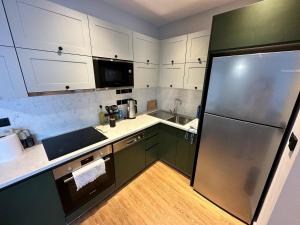 a kitchen with green cabinets and a refrigerator at Exclusive Residence Famagusta in Mağusa +34 photos