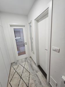 a white hallway with a door and a window at Urban Nest in Vranješ