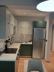 a kitchen with green and white cabinets and a refrigerator at Elegant Residence Famagusta in Famagusta +35 photos