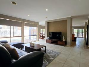 a living room with a couch and a tv at Sweet Home at Carrum Downs in Carrum Downs